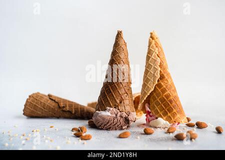 Umgedrehte Waffelstollen mit Eiscreme auf Betonhintergrund Stockfoto