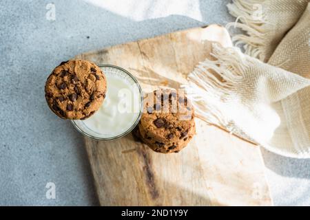 Gesunde Haferkekse mit Schokolade und ein Glas Joghurt auf dem Beton- oder Steintisch Stockfoto