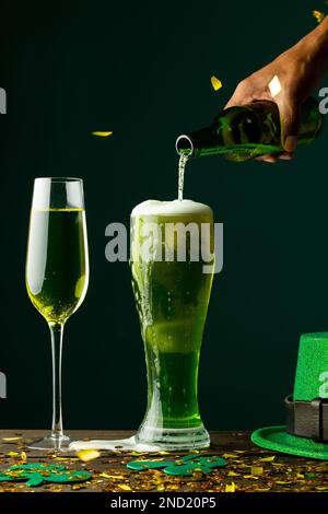 Bild: Bier- und Champagnergläser, grüner Hut und Kopierbereich auf grünem Hintergrund Stockfoto