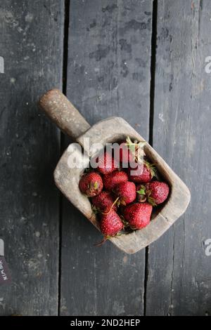 Frische Erdbeeren in einer Holzkiste. Auf Holzgrund. Draufsicht. Kopierbereich. Stockfoto