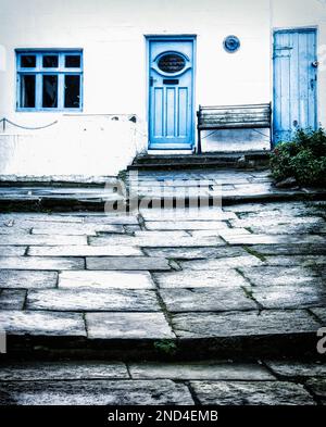 Blaue Türen eines Fischerhäuschen im zeitlosen Fischereihafen Staithes an der Küste von North Yorkshire. Stockfoto