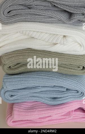 Gemütlicher Strickpullover als Hintergrund. Ein Haufen farbenfroher Strickpullover aus nächster Nähe Stockfoto