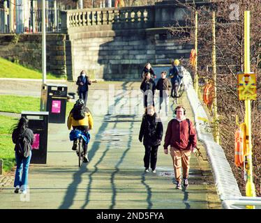 Glasgow, Schottland, Vereinigtes Königreich 15. Februar 2023. UK Weather: An einem sonnigen Tag kehrten die Menschen auf die Straßen zurück, um das Frühlingswetter zu genießen. Der clyde-Fußweg neben dem Fluss ist ein Magnet in der Frühlingssonne. Credit Gerard Ferry/Alamy Live News Stockfoto