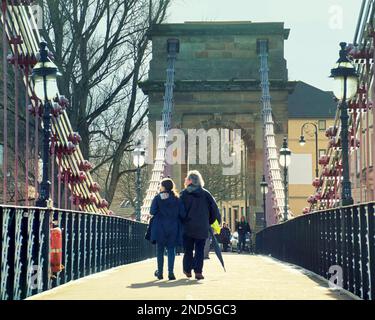 Glasgow, Schottland, Vereinigtes Königreich 15. Februar 2023. UK Weather: An einem sonnigen Tag kehrten die Menschen auf die Straßen zurück, um den Frühling wie das Wetter zu genießen. Die South Portland Street Hängebrücke und der Regenschirm werden im Frühlingswetter zu einem Wanderstock. Credit Gerard Ferry/Alamy Live News Stockfoto