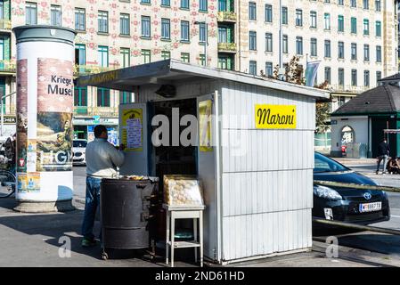 Wien, Österreich - 17. Oktober 2022: Verkäufer an seinem Stand, der Kastanien und Pommes frites im Naschmarkt, Street Food Markt in Wien, Österreich, röstet Stockfoto