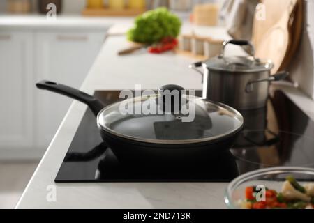 Bratpfanne mit Deckel auf der Herdplatte in der Küche Stockfoto