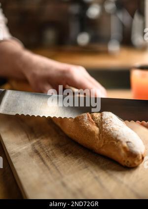 Ein Mädchen hat französisches Baguette mit einem Messer geschnitten Stockfoto