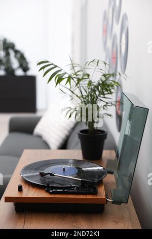 Eleganter Plattenspieler mit Vinylscheibe im Wohnzimmer Stockfoto