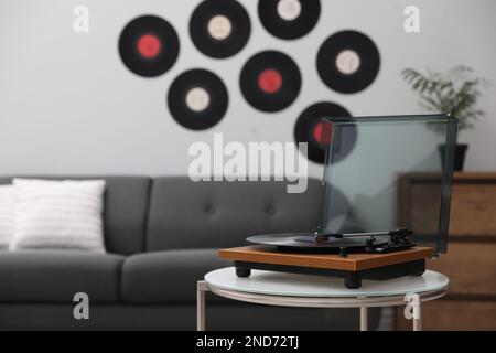 Eleganter Plattenspieler mit Vinylscheibe im Wohnzimmer Stockfoto