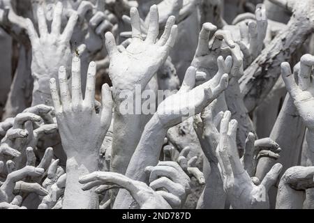 Hands flehend um Hilfe bei Wat Rong Khun bei Wat Rong Khun, Chiang Rai, Thailand. Stockfoto