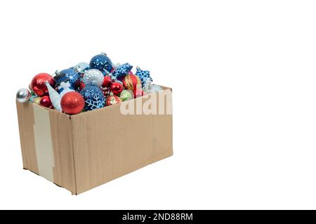 Horizontale Aufnahme einer Schachtel mit alten Weihnachtsdekorationen auf weißem Hintergrund mit viel Platz für Kopien. Das Kästchen befindet sich auf der linken Seite des Bildes. Stockfoto