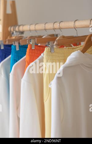 Kleidung hängt in einem Designer-Kleiderladen auf einem Regal. Kleiderbügel mit modischer Kleidung Stockfoto