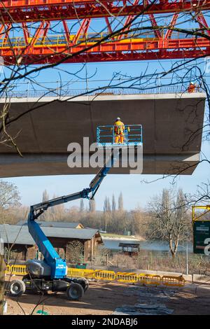 Denham, Großbritannien. 15. Februar 2023. Der HS2 High Speed Rail 2 Colne Valley Viadukt wird derzeit gebaut. Die Brücke überquert nun die A412 London Orbital Road in Denham. Dominque, ein riesiger, 160m m langer, orangefarbener Trägerbalken mit 700 Tonnen Gewicht, windet die Segmente von Dielen aus vorgegossenem Beton auf 56 Pier-Segmente. Es wurde berichtet, dass die Regierungsminister aufgrund des Projekts, das den Haushalt für HS2 erheblich überschritten hat, planen, HS2 Dienste sowie die vorgeschlagenen Zuggeschwindigkeiten zu kürzen, um Geld zu sparen. Kredit: Maureen McLean/Alamy Live News Stockfoto