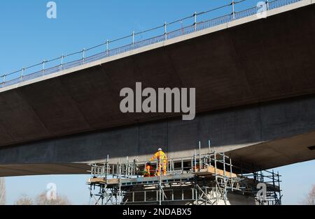 Denham, Großbritannien. 15. Februar 2023. Der HS2 High Speed Rail 2 Colne Valley Viadukt wird derzeit gebaut. Die Brücke überquert nun die A412 London Orbital Road in Denham. Dominque, ein riesiger, 160m m langer, orangefarbener Trägerbalken mit 700 Tonnen Gewicht, windet die Segmente von Dielen aus vorgegossenem Beton auf 56 Pier-Segmente. Es wurde berichtet, dass die Regierungsminister aufgrund des Projekts, das den Haushalt für HS2 erheblich überschritten hat, planen, HS2 Dienste sowie die vorgeschlagenen Zuggeschwindigkeiten zu kürzen, um Geld zu sparen. Kredit: Maureen McLean/Alamy Live News Stockfoto