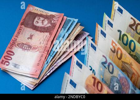 Ungarische Forint und 10-, 20-, 50-, 100-, 200-Euro-Banknoten werden auf eine Ebene Oberfläche gelegt. EUR-Wechselkurs HUF. Stockfoto