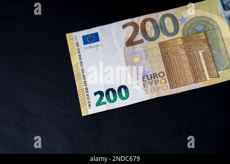 Nahaufnahme der 200-Euro-Banknote auf schwarzem Hintergrund für Themen der Unternehmensfinanzierung. Weltwährungskonzept, Inflation und Wirtschaftskonzept. Währung Nahaufnahme in d Stockfoto