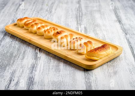 Eine Nahaufnahme von Gourmet-Marzipan-Brötchen-Figuren auf einem Holzteller Stockfoto