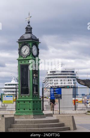 Punta Arenas, Chile - 27. Januar 2023: Grüner antiker Uhrenturm und Meteorologiestation mit Kreuzfahrtschiff Stockfoto