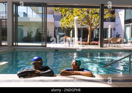 Ein afroamerikanisches Seniorenpaar, das sich im Pool ansieht. Altersruhestandsleben und Lebenskonzept Stockfoto