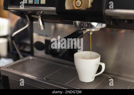 Nahaufnahme einer Tasse Kaffee aus der Kaffeemaschine im Café. Café, Freizeit und Stadtkonzept. Stockfoto