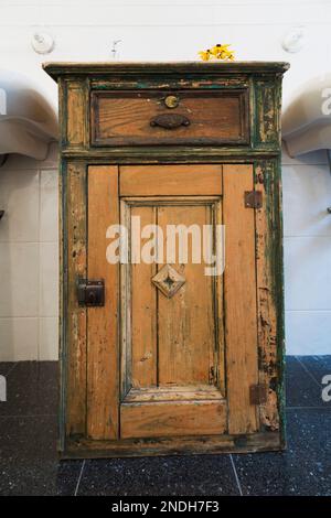 Alte verstörte Holzwaschbecken im Hauptbadezimmer im Obergeschoss im alten 1900 viktorianischen Queen Anne Revival-Haus. Stockfoto