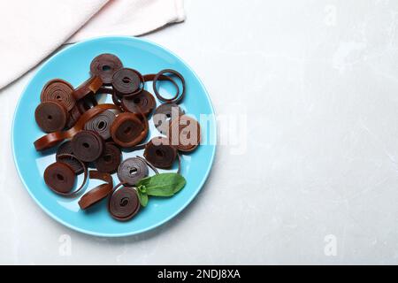 Köstliche Fruchtlederrollen auf einem hellen Tisch, Draufsicht. Platz für Text Stockfoto