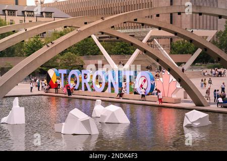 Toronto, Kanada - 07 01 2022 Uhr: Blick über den Brunnen am Nathan Phillips Square mit weißen Eisbergen auf dem Wasser vor dem erneuerten TORONTO Schild Stockfoto