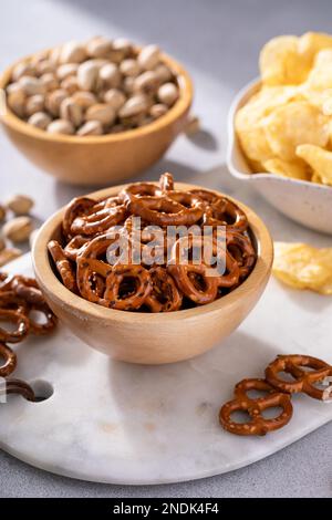 Auswahl an salzigen Snacks auf dem Tisch mit Brezeln, Pistazien und Kartoffelchips, Snacks, die gut zu Bier passen Stockfoto