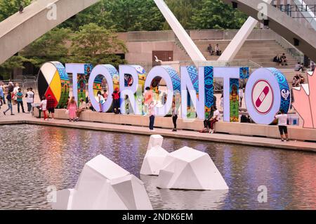 Toronto, Kanada - 07 01 2022: Erneuertes berühmtes TORONTO-Schild am Nathan Phillips Square in der Innenstadt von Toronto, das über den Brunnen mit weißen Eisbergen zu sehen ist Stockfoto