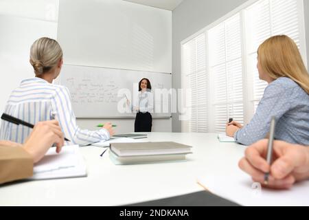 Englischlehrer, der in der Nähe des Whiteboards Unterricht gibt Stockfoto