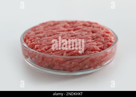 Petrischale mit rohem Hackfleisch auf weißem Tisch, Nahaufnahme Stockfoto