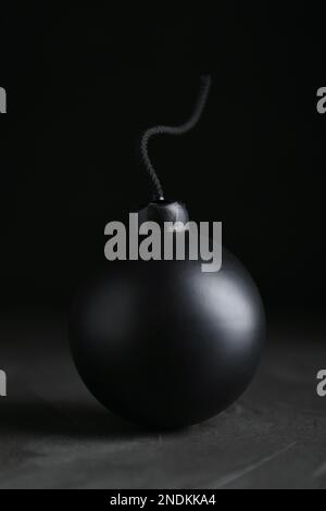 Kugelförmige Bombe mit Sicherung auf schwarzem Hintergrund Stockfoto