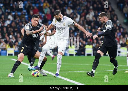 Madrid, Spanien. 15. Februar 2023. Karim Benzema (C) von Real Madrid wehrt sich mit Enzo Roco (L) und Raul Guti von Elche während eines spanischen Fußballspiels La Liga zwischen Real Madrid und Elche CF in Madrid, Spanien, am 15. Februar 2023. Kredit: Gustavo Valiente/Xinhua/Alamy Live News Stockfoto