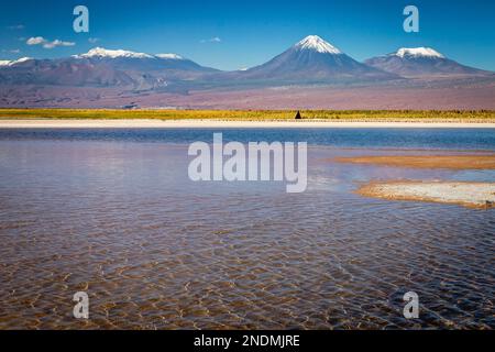 Licancabur und friedlicher Reflexionssee mit dramatischer vulkanischer Landschaft bei Sonnenuntergang, Atacama Wüste, Chile Stockfoto