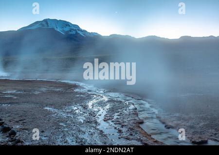 Geysire El Tatio mit Fluss und friedlicher, dramatischer vulkanischer Landschaft bei Sonnenaufgang, Atacama-Wüste, Chile Stockfoto