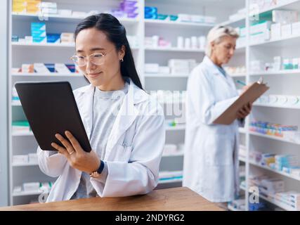 Asiatische Frau, Tablette und Apotheker in der Apotheke für Gesundheitswesen, Telehealth oder Bestandskontrolle. Medizin Shop, Technologie und weibliche Ärztin mit Stockfoto