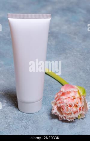 Modell einer leeren weißen Packung mit Tulpen auf blauem Hintergrund für eine Inschrift Stockfoto