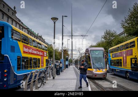 Busse und Straßenbahnen in der O'Connell Street, im Hintergrund Turmspitze von Dublin auch als Monument von Licht von Ian Ritchie Architects, Dublin, Irland Stockfoto