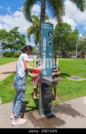 Frau füllt eine Flasche mit kostenlosem gefiltertem Wasser auf der Cairns Esplanade, Far North Queensland, FNQ, QLD, Australien Stockfoto