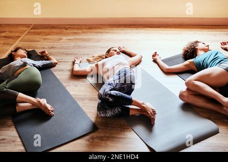 Nach einem Yoga-Kurs ist das Leben am einfachsten. Eine Gruppe junger Frauen, die sich nach ihrem Yoga-Kurs ausruhen. Stockfoto