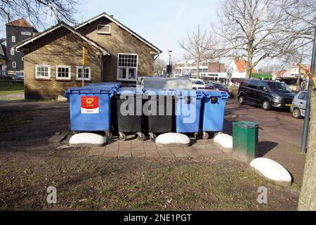 Kunststoffbehälter zum Auffangen von Altpapier im niederländischen Dorf Bergen. Hinter ihnen Behälter zum Auffangen von Glas. Niederlande, Februar Stockfoto