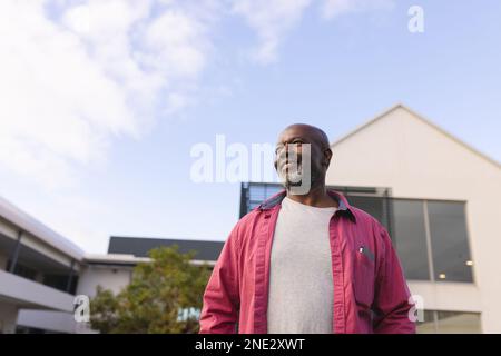 afroamerikanischer Seniorist, der lächelt, während er nach draußen blickt. Altersruhestandsleben und Lebenskonzept Stockfoto
