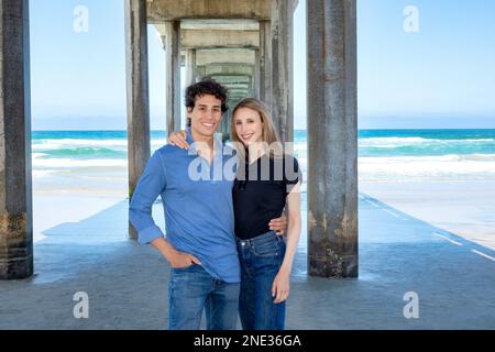 Junges Paar, das am Scripps Pier, La Jolla, Kalifornien, interlaced war Stockfoto