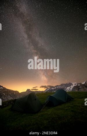 Nachtaufnahme der Milchstraße, an einem Bergsee, zwei Zelte im Vordergrund Stockfoto