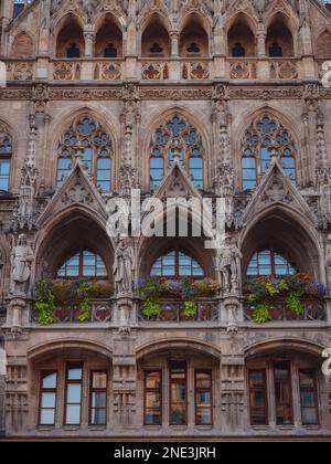 Fassade des neogotischen Rathauses mit täglichen Aufführungen zum Glockengeräusch und einem hohen Turm mit Blick auf die Stadt am Marienplatz München Stockfoto