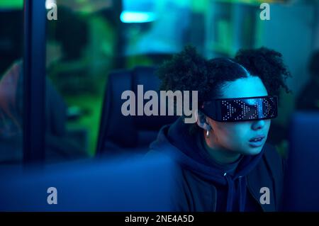 Hacker, Cyberpunk und Neon Woman, die Software hacken, Online-Server oder Passwort-Phishing programmieren. Blauer Ransomware-Entwickler, Cybersicherheit Stockfoto