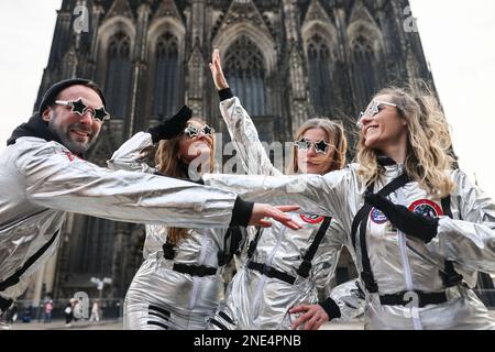 Köln, Deutschland. 16. Februar 2023. Als Astronauten verkleidete Karnevalisten stehen vor der Kathedrale. Traditionell beginnt der Straßenkarneval mit der Weiberfastnacht. Zum ersten Mal seit drei Jahren gibt es keine Corona-Beschränkungen mehr. Kredit: Oliver Berg/dpa/Alamy Live News Stockfoto