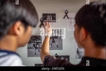 Chiang Mai, Thailand. 16. Februar 2023. Schüler der Vachiralai Bee School sehen die Erinnerungsfotos ihres Mitschülers Duangpetch Promthep (Dom) nach seinem Tod. Duangpetch Promthep (Dom), 17 Jahre alt, ehemaliger Student an der Vachiralai Bee School in Chiang Mai, bevor er ein Fußballstipendium in Großbritannien gewann, wo er an der Brooke House College Football Academy in Leicester studierte. Er war Kapitän der Wildschweine-Fußballmannschaft 1 der 13 „Wildschweine“, die aus der Tham Luang Höhle gerettet wurden. Kredit: SOPA Images Limited/Alamy Live News Stockfoto