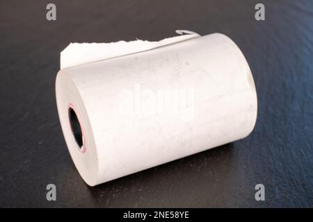 Eine Papierrolle Kassenband auf Schieferstein, Nahaufnahme. Stockfoto