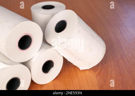 Mehrere Papierrollen Kassenband auf dem Schreibtisch, Nahaufnahme. Stockfoto